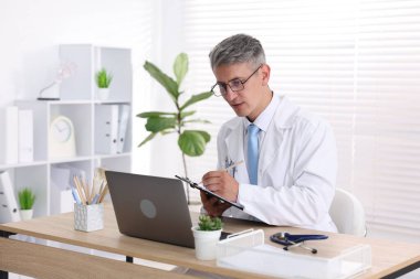 Teletıp. Doktor içeride bilgisayarla hastayla görüntülü konuşma yaparken not alıyor.