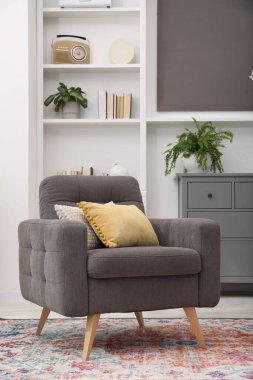 Kapalı yerde yastıklı gri koltuk. İç tasarım