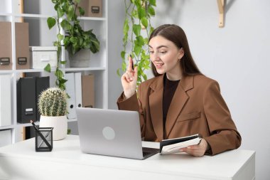 Ofiste bilgisayarla görüntülü konuşma yapan bir kadın.