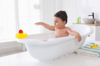 Evde küvette banyo yapan şirin bir bebek.