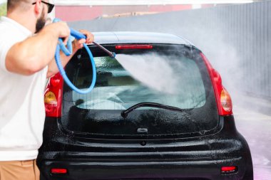 Oto yıkayan adam yüksek basınçlı su jeti ile oto yıkama, yakın çekim