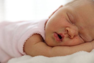 Yeni doğmuş şirin bebek evde yatakta uyuyor.