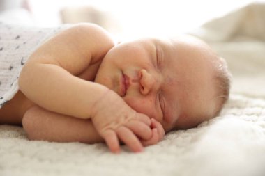 Yeni doğmuş şirin bebek evde yatakta uyuyor.