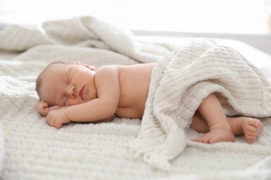 Yeni doğmuş şirin bebek evde yatakta uyuyor.