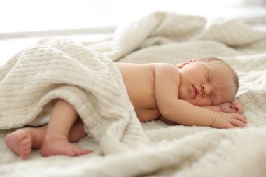 Yeni doğmuş şirin bebek evde yatakta uyuyor.