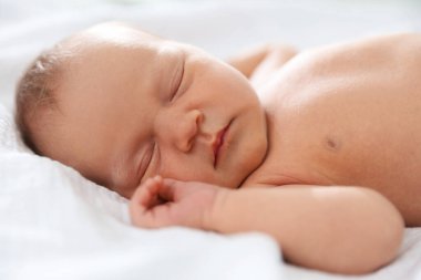 Yeni doğmuş şirin bebek evde yatakta uyuyor.