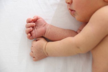 Sevimli yeni doğmuş bebek yatağında yatıyor.