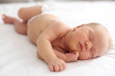 Yeni doğmuş şirin bebek evde yatakta uyuyor.