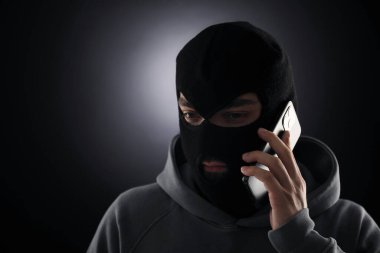 Maskeli bir suçlu karanlık geçmişiyle telefonda konuşuyor. Metin için boşluk