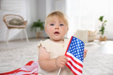 Evinde yerde Amerikan bayrağı taşıyan şirin bir çocuk.