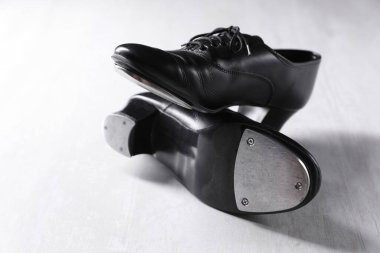 Beyaz tahta zeminde step dansı için bir çift ayakkabı, yakın plan.