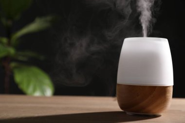 Ahşap masa üzerinde modern aroma lambası. Metin için boşluk