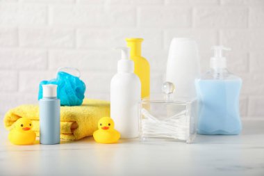 Tuğla duvarın yanındaki masada çok farklı bebek banyosu gereksinimleri var.