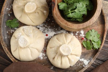 Ahşap masada biber ve maydanozlu pişmemiş khinkaliler (hamur tatlısı).