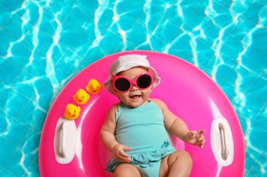 Yüzme havuzunda şişirilebilir yüzüklü şirin bir bebek.