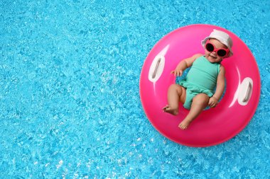 Yüzme havuzunda şişirilebilir yüzüklü şirin bir bebek. Metin için boşluk
