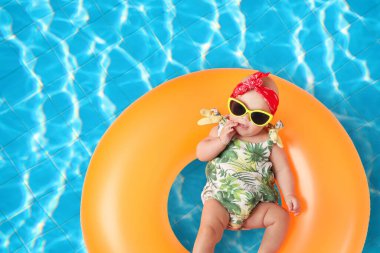 Yüzme havuzunda şişirilebilir yüzüklü şirin bir bebek.