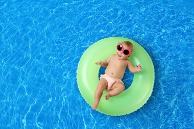 Yüzme havuzunda şişirilebilir yüzüklü şirin bir bebek. Metin için boşluk