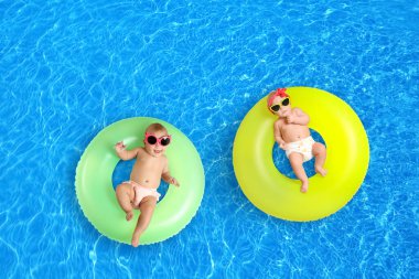 Yüzme havuzunda şişme halkaları olan şirin küçük bebekler.