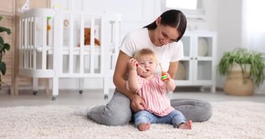 Anne ve küçük tatlı çocuğu bebek odasında oyuncaklarla oynuyorlar.
