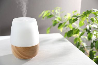 Beyaz ahşap masa üzerinde modern aroma lambası.
