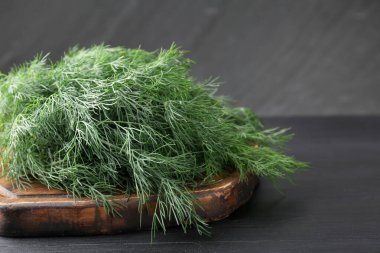 Siyah ahşap masada taze dereotu var, yakın plan.