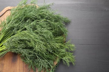 Siyah ahşap masanın üstünde taze dereotu var. Metin için boşluk