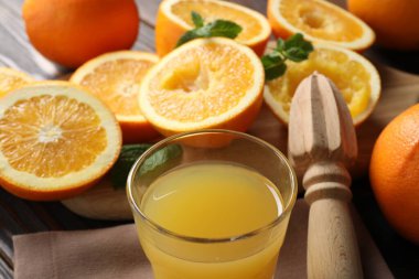 Taze sıkılmış portakal suyu, naneli meyve suyu, meyve sıkacağı ve havlu, yakın plan.