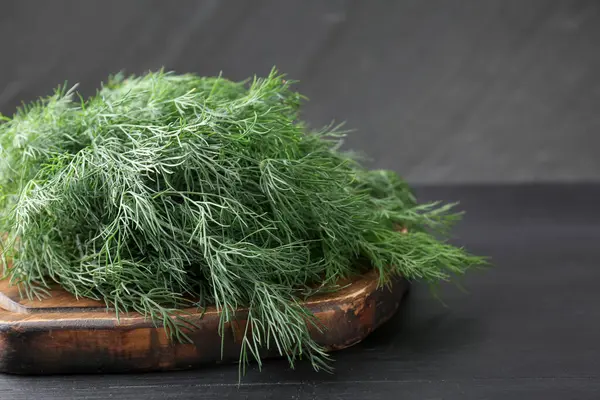 Siyah ahşap masada taze dereotu var, yakın plan.