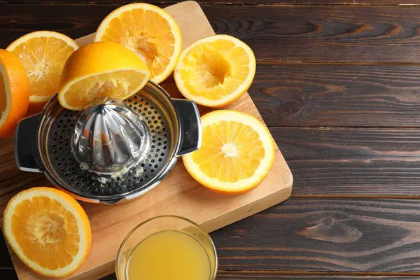 Taze sıkılmış portakal suyu, meyve suyu ve meyve sıkacağı ahşap masada, manzaranın üstünde. Metin için boşluk