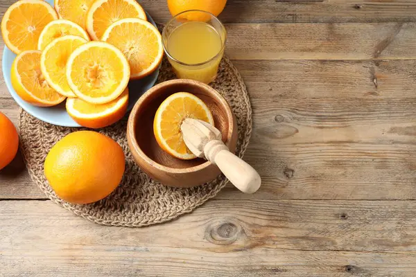 Taze sıkılmış portakal suyu, meyve suyu ve meyve sıkacağı ahşap masada, manzaranın üstünde. Metin için boşluk