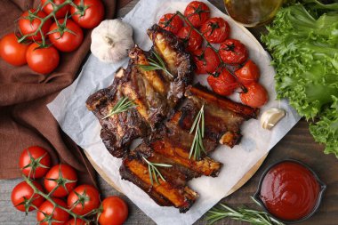 Baharatlı, domatesli ve ahşap masada domates soslu kızarmış sığır kaburgası.