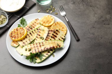 Üzerinde balkabağı tohumları, limon ve maydanoz olan leziz ızgara kabak dilimleri. Metin için boşluk