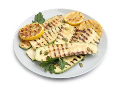 Lezzetli ızgara kabak dilimleri, kabak çekirdekleri, limon ve maydanoz, beyaz üzerine izole edilmiş.