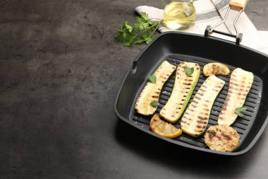 Gri desenli masada tavada sarımsak, limon ve maydanozlu lezzetli kabak dilimleri, yakın plan. Metin için boşluk