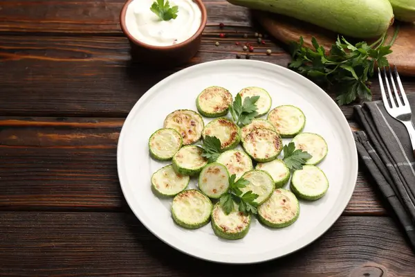 Ahşap masada servis edilen maydanozlu lezzetli kabak dilimleri, yakın plan.