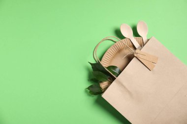 Farklı çevre dostu paketleme, sofra takımı ve açık yeşil arka planda bırakmalar, üst manzara. Metin için boşluk