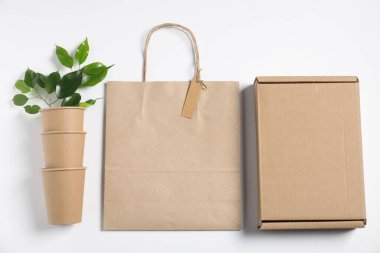 Farklı çevre dostu ambalaj, beyaz arka planda fincanlar ve yapraklar, düz uzanma