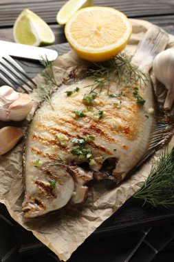 Ahşap masada servis edilen baharatlı kızarmış balık, yakın plan. Ev yapımı deniz ürünleri yemeği.