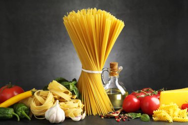 Siyah masada değişik makarna ve malzemeler var.