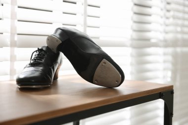 Kapalı alanda, ahşap rafta step dansı için bir çift ayakkabı.