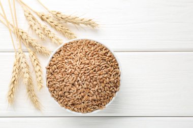 Kasede buğday taneleri, beyaz ahşap masada çiviler düz yerde. Metin için boşluk