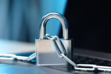 Siber güvenlik. Bilgisayarında zincir olan metal asma kilit, yakın plan.