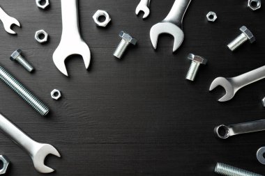 Bir sürü metal anahtar, cıvata ve somun siyah ahşap masa, düz yatıyordu. Metin için boşluk