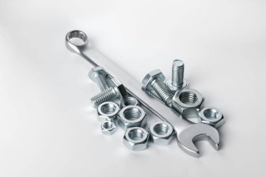 Beyaz arka planda metal anahtar, cıvata ve fındık