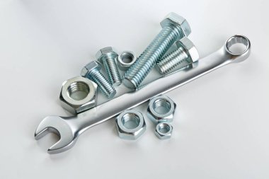 Beyaz arka planda metal anahtar, cıvata ve fındık