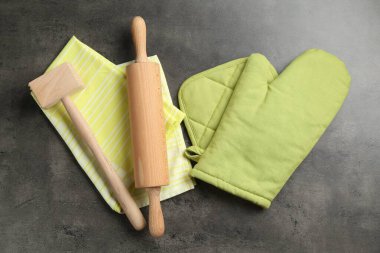 Yeşil fırın eldiveni ve diğer mutfak gereçleri koyu dokulu masa, düz yatıyordu.