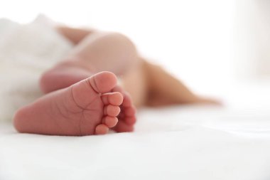 Yeni doğmuş şirin bebek yatakta uzanıyor, yakın plan. Metin için boşluk