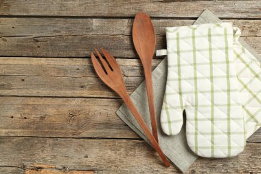 Fırın eldiveni ve diğer mutfak gereçleri ahşap masada, düz yerde. Metin için boşluk