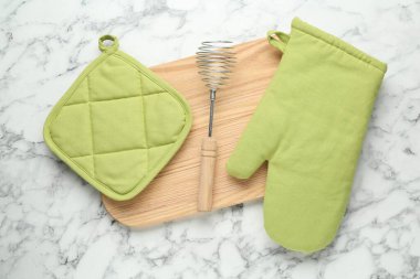 Fırın eldiveni, tutkal ve diğer mutfak gereçleri beyaz mermer masa, düz yatıyordu.